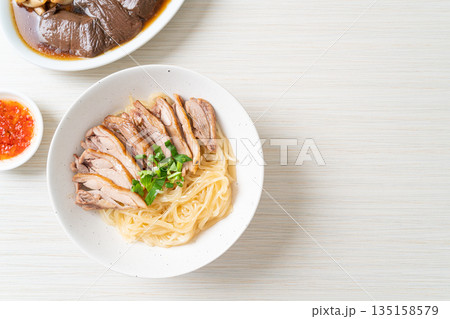 dried noodles with stewed duck in white bowl 135158579