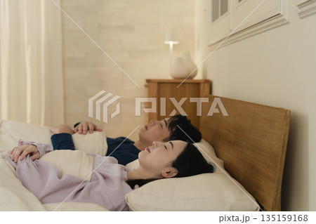 ベッドで眠る若い男性と女性 ライフスタイルイメージ ベッドで眠る若い男性と女性 ライフスタイルイメージ 135159168