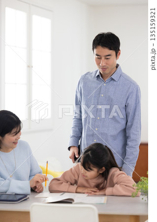 両親と一緒に自宅で学習を楽しむ小学生の女の子 両親と一緒に自宅で学習を楽しむ小学生の女の子 135159321