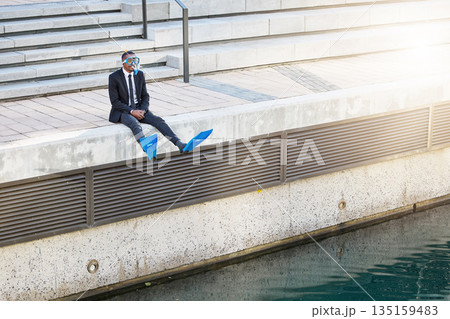 Businessman, travel and snorkel mask for holiday, ready for vacation and ocean adventure. Scuba, diving and man sitting at water, waves or excited for break from work, experience or summer trip 135159483