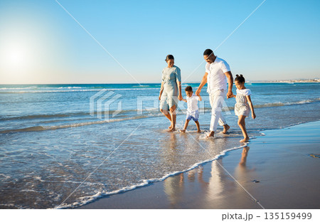Family travel, beach walking and holding hands with mother, father and kids at ocean on holiday. Vacation and parent care with mockup in summer outdoor with mom, dad and children by sea having fun Family travel, beach walking and holding hands with mother, father and kids at ocean on holiday. Vacation and parent care with mockup in summer outdoor with mom, dad and children by sea having fun 135159499