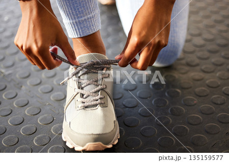 Tie, gym or hands of person with shoes at gym for training, exercise or workout routine in fitness center. Lace, zoom or leg of sports athlete with footwear ready to start exercising on studio floor 135159577