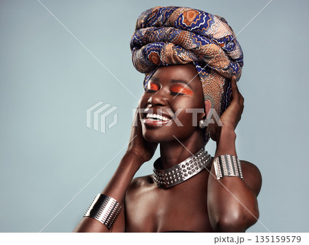 Beauty, black woman and smile with African head scarf and mockup in a studio. Isolated, blue background traditional Africa turban with a young female model with culture and pride with cosmetics 135159579