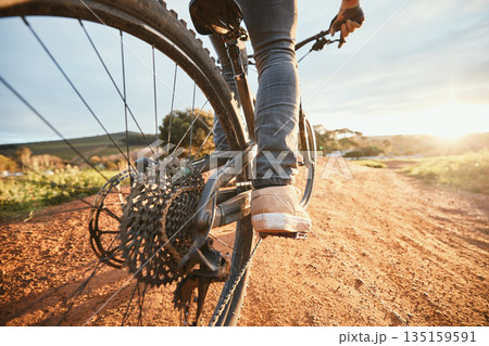 Feet, cycling and a man on a bike and dirt road for fitness, morning cardio or adventure in nature. Sports, tire and a person on a bicycle for a race, competition or exercise in the countryside Feet, cycling and a man on a bike and dirt road for fitness, morning cardio or adventure in nature. Sports, tire and a person on a bicycle for a race, competition or exercise in the countryside 135159591