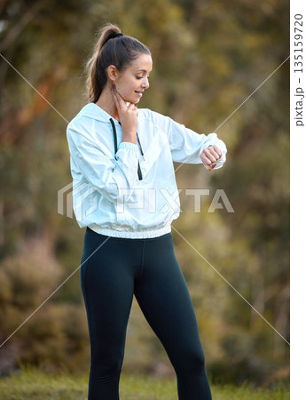 Fitness, watch and heart rate with a woman runner outdoor checking pulse during a cardio or endurance workout. Exercise, health and bpm with a young female athlete looking at the time while running 135159720
