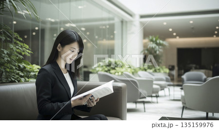 ロビーで読書をしているスーツ姿の女性 ロビーで読書をしているスーツ姿の女性 135159976