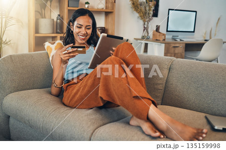 Woman on sofa with tablet, credit card and online shopping of fintech payment on ecommerce at home. Happy female customer in apartment, bank app or sale on store website with digital internet banking Woman on sofa with tablet, credit card and online shopping of fintech payment on ecommerce at home. Happy female customer in apartment, bank app or sale on store website with digital internet banking 135159998