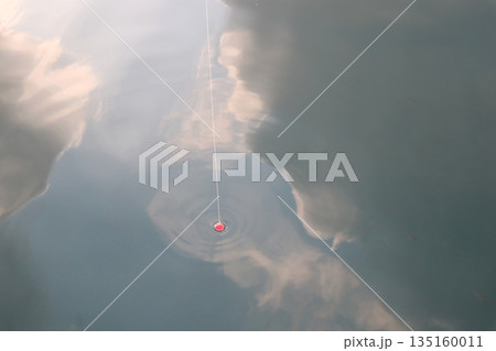 海に写った雲と釣り糸とウキ 135160011