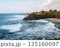 Tanah Lot temple Bali ocean waves crashing rock, iconic Hindu shrine on cliff amid turquoise sea lush greenery blue sky exotic tropical Indonesian coastal paradise serene landscape travel destination 135160097