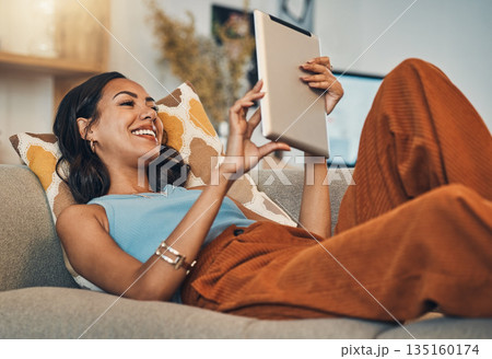Woman relax on sofa with tablet, online streaming with internet and reading ebook or watching film at home. Happy female person with technology, subscription and mobile app with break in living room Woman relax on sofa with tablet, online streaming with internet and reading ebook or watching film at home. Happy female person with technology, subscription and mobile app with break in living room 135160174