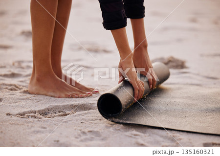Woman, yoga and beach with hand and feet for rolling mat with clean wellness or fitness. Female person, meditation and yogi on seashore with hands in the outdoor for start in the morning and pilates. 135160321