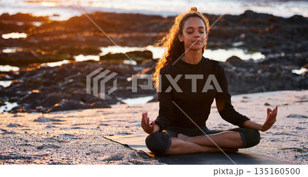 Woman, beach yoga and sunset with lotus, eyes closed and peace of mind in summer sunshine. Girl, zen meditation and mindfulness for health, wellness and exercise by ocean, chakra balance and energy 135160500