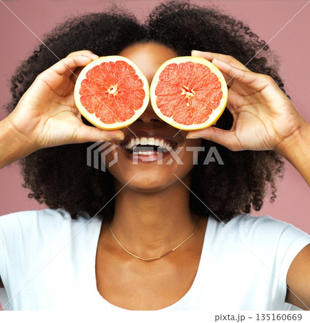 Grapefruit, happy and black woman covering her eyes in studio isolated on a pink background. Funny, fruit and African female model with vegan nutrition, vitamin c or healthy diet, food and wellness. 135160669