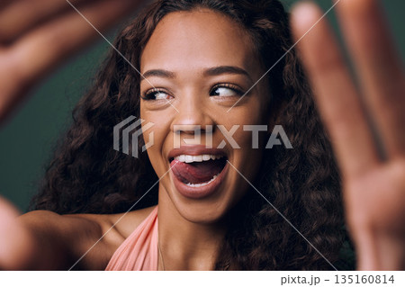 Selfie, tongue out and happy gen z girl with natural beauty, hair or smile on green background. Face, emoji and female influencer with fun, quirky or silly in studio for profile picture or blog Selfie, tongue out and happy gen z girl with natural beauty, hair or smile on green background. Face, emoji and female influencer with fun, quirky or silly in studio for profile picture or blog 135160814