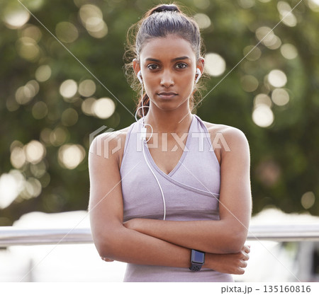 Serious portrait of fitness woman with earphones in park, commitment and listening to music or podcast. Exercise, training and girl with headphones and focus for radio streaming and running in nature Serious portrait of fitness woman with earphones in park, commitment and listening to music or podcast. Exercise, training and girl with headphones and focus for radio streaming and running in nature 135160816