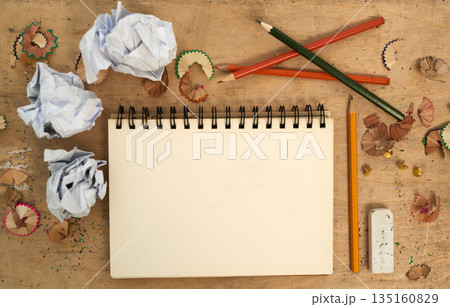 Stationary, notebook with color pencil and on table with paper. Mock up space or planning, abstract or top view and sketchpad or drawing book for creative art or design with eraser at messy desk Stationary, notebook with color pencil and on table with paper. Mock up space or planning, abstract or top view and sketchpad or drawing book for creative art or design with eraser at messy desk 135160829