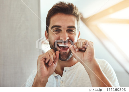 Dental floss, teeth and smile with portrait of man in bathroom for cleaning, morning and oral hygiene. Happy, cosmetics and health with face of person flossing at home for self care, breath and mouth 135160898