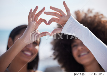 Friends, closeup and heart hands with women at beach for summer, happy and teamwork. Support, freedom and love with people and holding shape in outdoors for collaboration, faith and community gesture Friends, closeup and heart hands with women at beach for summer, happy and teamwork. Support, freedom and love with people and holding shape in outdoors for collaboration, faith and community gesture 135161047