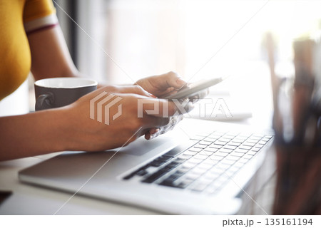 Woman, hands and phone at a laptop desk for work networking and employee typing. Female worker, table and social network app with mobile communication and text for professional and web connection 135161194