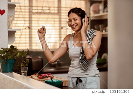 Music headphones, dancing and woman cooking with fruit, strawberry and food. Dance, headphone and female person making breakfast while listening to audio, sound and radio podcast in happy kitchen. 135161305