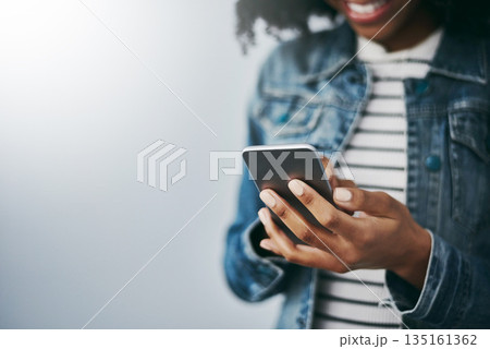 Hands, cellphone and woman with typing by wall background with texting, mockup space or email on web. African girl, smartphone and chat for blog, post or video on social network app for connectivity 135161362