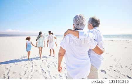 Big family, sea or old couple walking with children in summer with happiness, trust or peace in nature. Grandparents, back view or senior man bonding with woman or kids taking a walk on beach sand 135161856