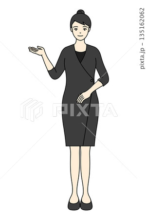 シックな黒い制服で右手を差し出し案内する女性セラピスト 135162062