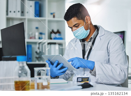 Scientist man, tablet and typing in lab for medical, pharmaceutical or covid research in face mask. Young male doctor, innovation and website for test, check and science app for virus in laboratory 135162134