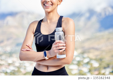 Woman is outdoor with water bottle, fitness and break after training, health and hydration with mockup space. Female athlete smile, workout and exercise in nature with h2o drink, minerals and liquid 135162348
