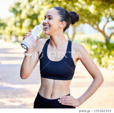Happy woman, fitness and laughing with water bottle in rest from fun running, exercise or cardio workout in park. Fit, active or thirsty female person, athlete or runner with smile for sustainability 135162353
