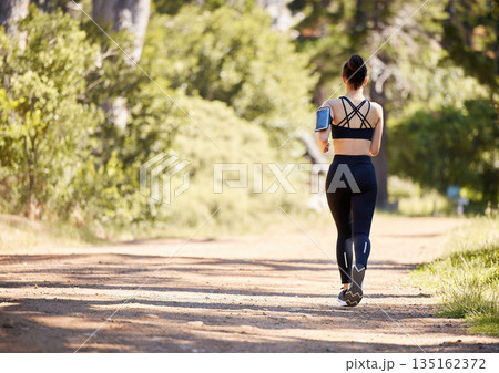 Woman, fitness and running in nature for exercise, cardio workout or training in the outdoors. Rear view of fit, active and sports female person, athlete or runner exercising for healthy wellness Woman, fitness and running in nature for exercise, cardio workout or training in the outdoors. Rear view of fit, active and sports female person, athlete or runner exercising for healthy wellness 135162372