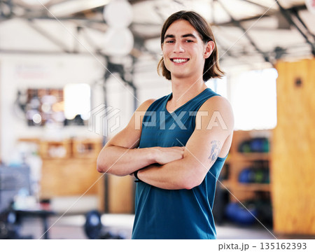 Coach, portrait and man with arms crossed in gym ready to start training, workout or exercise for health and wellness. Fitness, face and smile of confident athlete or personal trainer from Canada. 135162393