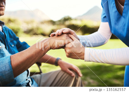 Senior, nurse and holding hands in wheelchair for healthcare support, love or elderly care compassion in nature. Hand of caregiver helping man patient or person with a disability outside nursing home 135162557