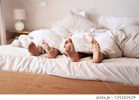 Sleep, bedroom legs and tired couple relax at home, cozy and peace for morning health, wellness and fatigue. Blanket, feet and exhausted man, woman or people sleeping for comfort in apartment bed 135162629