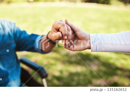 Senior, caregiver and holding hands on wheelchair in support, love or healthcare for life insurance in nature. Hand of nurse helping male patient or person with a disability at nursing home outdoors Senior, caregiver and holding hands on wheelchair in support, love or healthcare for life insurance in nature. Hand of nurse helping male patient or person with a disability at nursing home outdoors 135162652