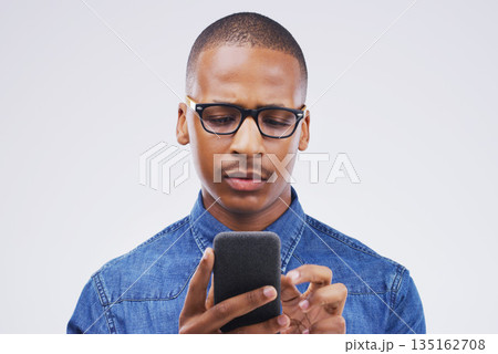 Phone, communication and serious black man in studio typing for social media, internet and online chat. Mockup, white background and male person on smartphone for website, mobile app and network Phone, communication and serious black man in studio typing for social media, internet and online chat. Mockup, white background and male person on smartphone for website, mobile app and network 135162708