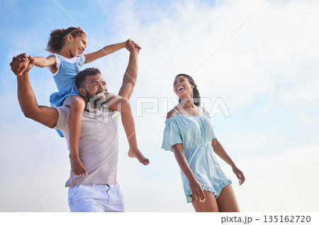 Piggyback, sea or parents walking with a child for a holiday vacation together with happiness in summer. Holding hands, mother and father playing or enjoying family time with a happy girl or kid Piggyback, sea or parents walking with a child for a holiday vacation together with happiness in summer. Holding hands, mother and father playing or enjoying family time with a happy girl or kid 135162720