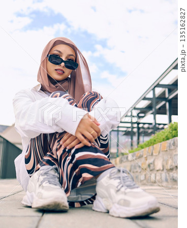 Portrait, fashion or hijab with a muslim woman outdoor in sunglasses and a scarf for contemporary style. Islam, faith or religion with a trendy young arab person posing outside in modern clothing 135162827