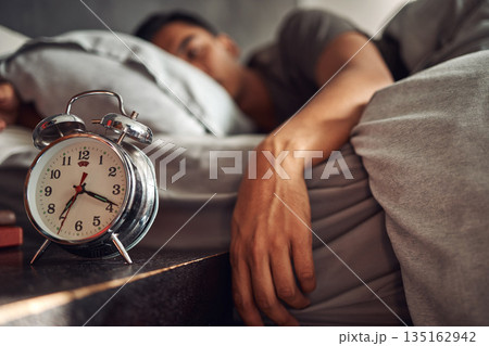 Alarm clock, relax and man sleeping in the bed of his modern apartment in the morning. Lazy, resting and closeup of a timer bell with a male person taking a nap and dreaming in bedroom at his home. Alarm clock, relax and man sleeping in the bed of his modern apartment in the morning. Lazy, resting and closeup of a timer bell with a male person taking a nap and dreaming in bedroom at his home. 135162942