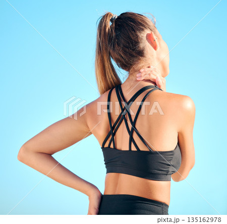 Fitness, back view of woman with neck pain and in blue sky outdoors for yoga exercise. Workout or training for health wellness, sports athlete and female person struggling with cramp in muscle Fitness, back view of woman with neck pain and in blue sky outdoors for yoga exercise. Workout or training for health wellness, sports athlete and female person struggling with cramp in muscle 135162978