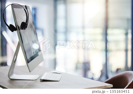 Call center, headset and desk with computer in office for consulting, crm and technology communication or help. Workplace, customer service or telemarketing pc on desktop for work, agency or support 135163451