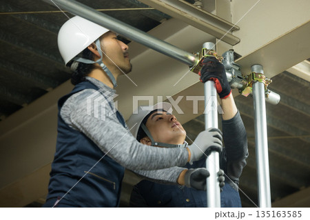 工場現場で単管パイプを組む作業員  135163585
