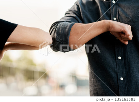 Closeup, man and woman elbow greeting to avoid the spread of coronavirus or COVID-19 infection and outdoors. Social distancing, health and wellness or fear of pandemic or meet in the street outside 135163593