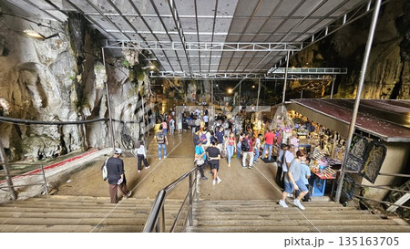 This is cave diorama features golden temples, ritual figures, and natural rock textures, blending Hindu symbolism in Batu Cave inside 135163705