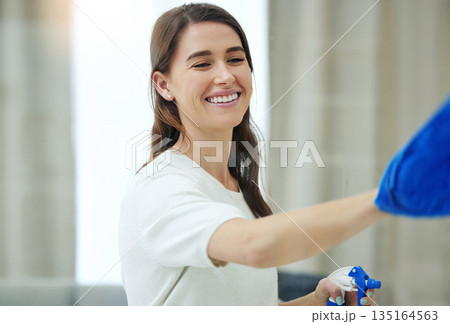 Spray bottle, cleaning window and woman with smile for hygiene, housework and chores at home. Housework, housekeeping and happy female person with detergent, chemical and antibacterial products 135164563