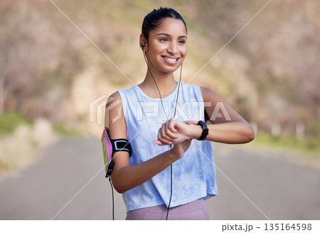 Fitness, smartwatch and woman on a break from running in the road for race or marathon training. Sports, workout and female athlete checking the time for her outdoor cardio exercise in the street. 135164598