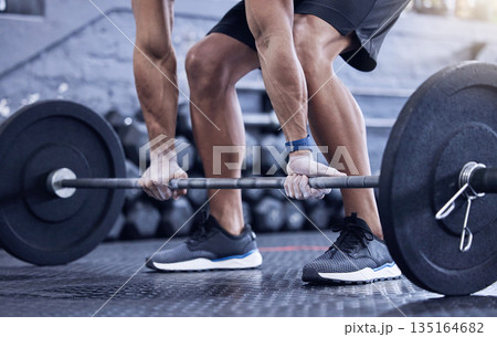 Man, training and lift weight with hands at the gym with legs for wellness with exercise. Male athlete, barbell and workout with hand at a club for strong muscles for lifting the fitness equipment. Man, training and lift weight with hands at the gym with legs for wellness with exercise. Male athlete, barbell and workout with hand at a club for strong muscles for lifting the fitness equipment. 135164682