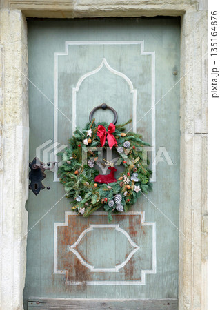 Natural spruce Advent christmas wreath on the vintage wooden door. Natural spruce Advent christmas wreath on the vintage wooden door. 135164876