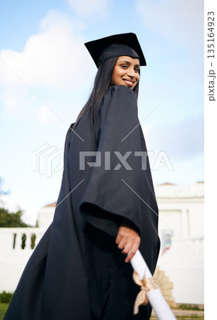 Portrait, certificate and back with a woman graduate on university campus for a celebration event outdoor. Graduation, education and future with a happy young female student alone outside at college Portrait, certificate and back with a woman graduate on university campus for a celebration event outdoor. Graduation, education and future with a happy young female student alone outside at college 135164923