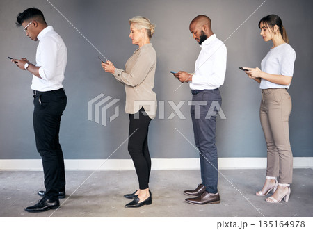 Business people, phone and networking in waiting room or line for interview, hiring or communication. Group of employees standing in row on smartphone for job search, opportunity or social media 135164978